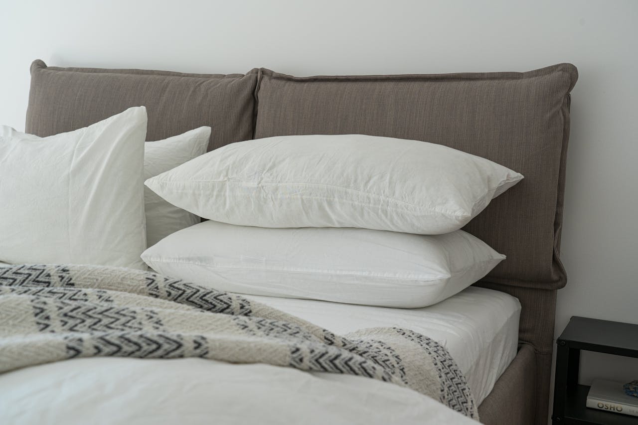 Modern bedroom featuring clean white bedding and pillows for a cozy and inviting atmosphere.